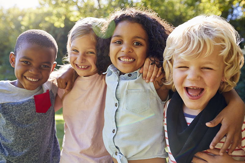 Lachende Kinder umarmen sich